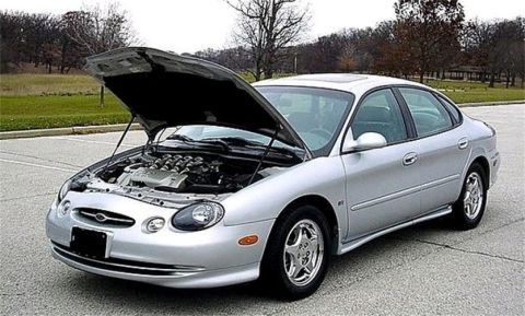 1998 Ford Taurus - Silver 1998 Ford Taurus with the hood open, parked outdoors on asphalt.