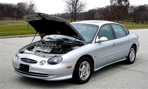 1998 Ford Taurus - A silver sedan, likely a 2000 Ford Taurus, is parked with its hood open, revealing the engine compartment.