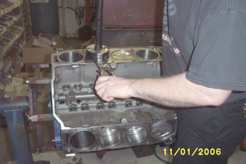 1967 Ford Galaxie - A mechanic measures the cylinders of an engine block with a bore gauge.
