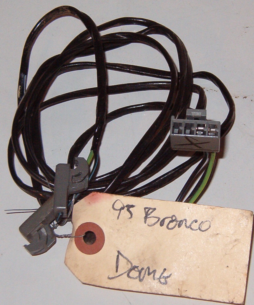 Coiled wiring harness with connectors and a paper tag reading 95 Bronco dome