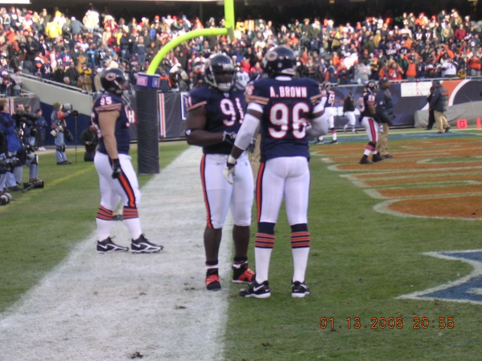Football players in uniform on a field with spectators in the background