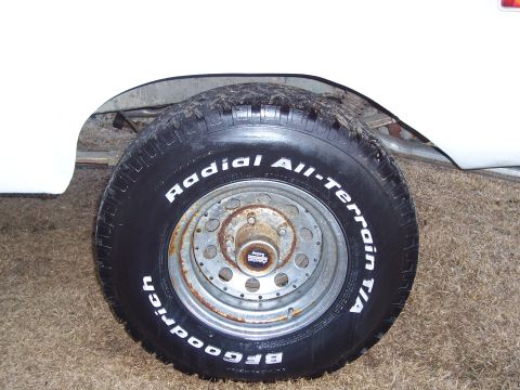 1974 Ford Bronco - A close-up of a vehicle's wheel and tire shows rust and all-terrain tread.