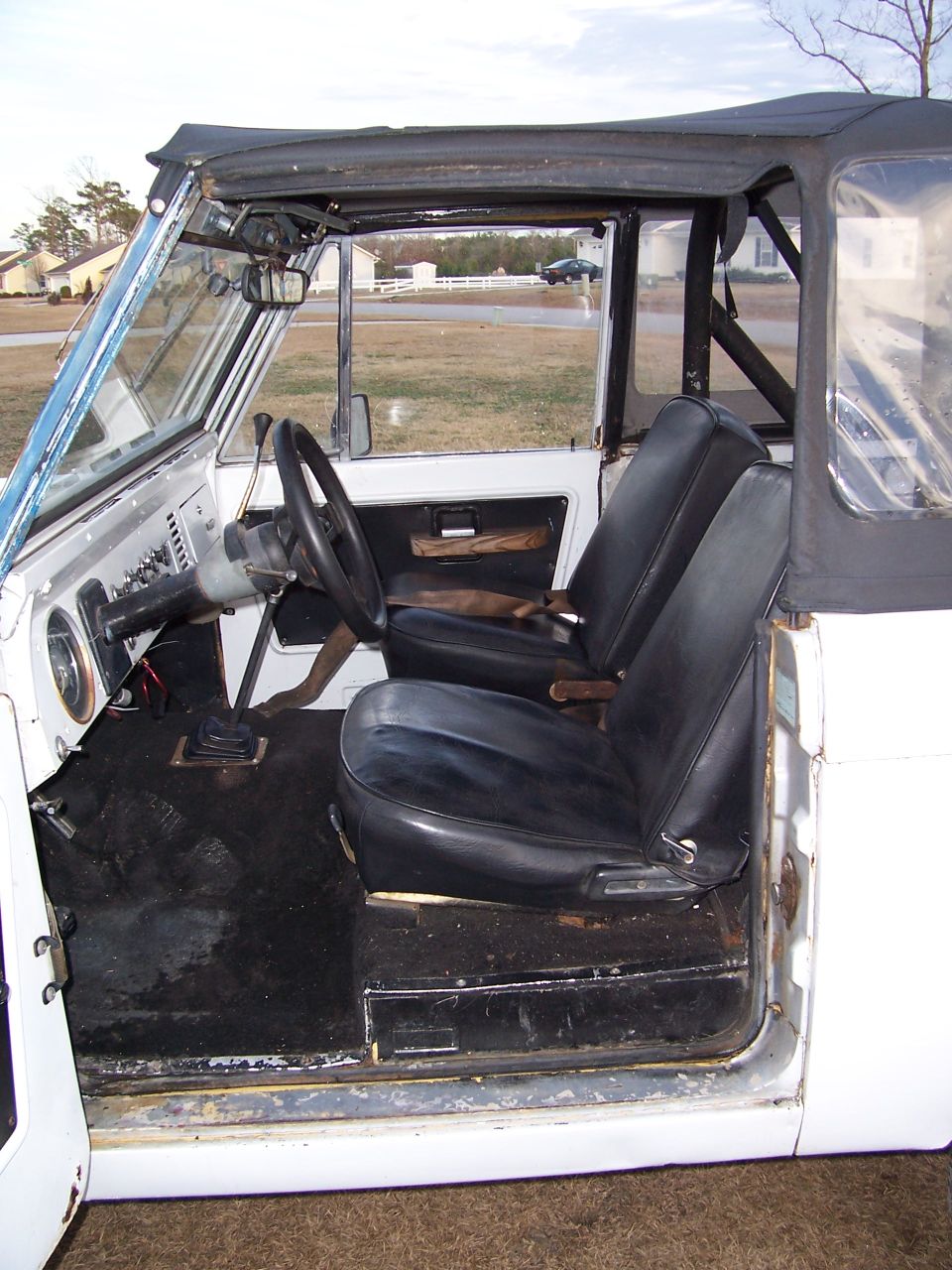 1974 Ford Bronco interior showing front seats, dashboard, and steering wheel