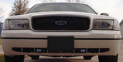 2000 Ford Crown Victoria - Front view of a white 2000 Ford Crown Victoria, showing its black grille, Ford emblem, and headlights.
