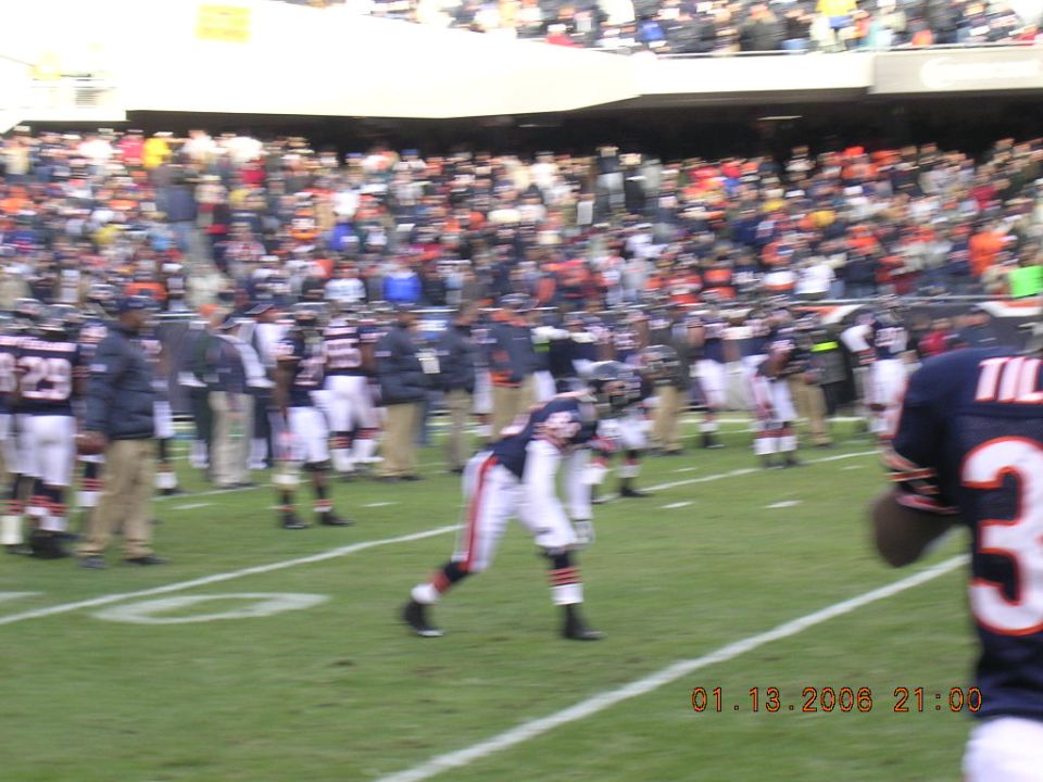 Football players on a field with spectators in the background and a date stamp