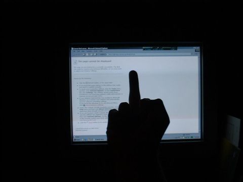 1985 Ford LTD Crown Victoria - Photograph of a hand in front of a glowing monitor, not a technical document.