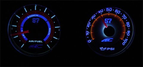 1993 Ford Probe - Two aftermarket gauges, an air/fuel ratio meter and a PSI gauge, illuminated in the dark.