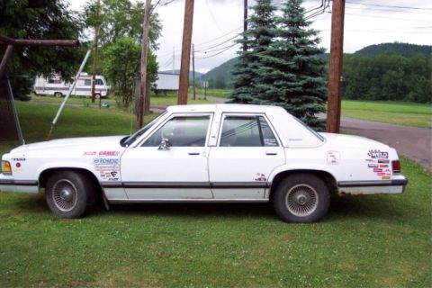 1988 Mercury Grand Marquis - This 1988 Mercury Grand Marquis is covered in various stickers on its side.