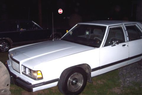 1988 Mercury Grand Marquis - This 1988 Mercury Grand Marquis is parked next to another car at night.