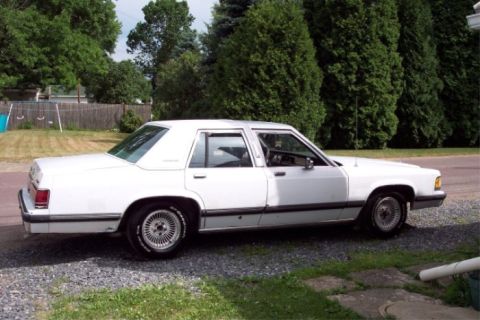 1988 Mercury Grand Marquis - This 1988 Mercury Grand Marquis sedan is shown from the side, parked on a gravel driveway.