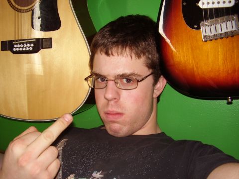 1996 Ford F-150 - A man poses with two guitars behind him, making an offensive gesture.