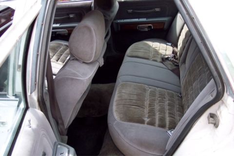 1988 Mercury Grand Marquis - Interior view of a car's back seat and door panel, showing the fabric upholstery.