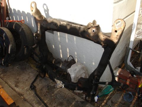 1993 Ford Taurus - A detached subframe assembly, likely from a car, is shown resting on the ground.