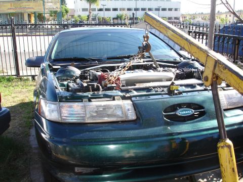 1993 Ford Taurus - Engine removal in progress on a 1993 Ford Taurus using an engine hoist.