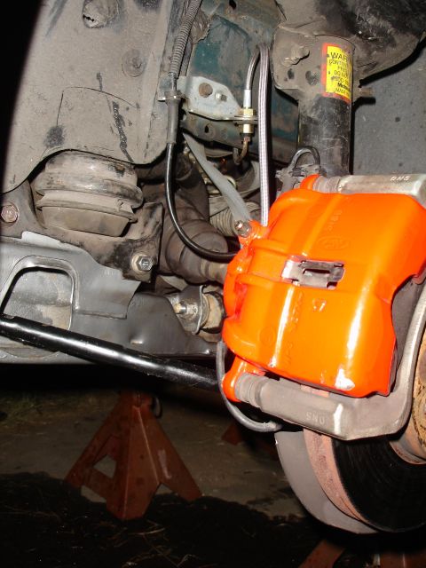 1993 Ford Taurus - Close-up view of a vehicle's suspension and braking system, supported by jack stands.