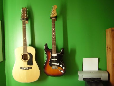 1996 Ford F-150 - A 12-string acoustic and a sunburst electric guitar are mounted on a vibrant green wall above a printer.