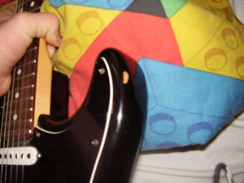 1996 Ford F-150 - A close-up view of a black electric guitar body, showing some wear and tear.