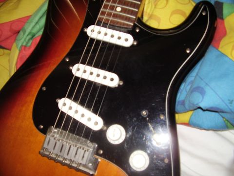 1996 Ford F-150 - This electric guitar features a sunburst finish and a black pickguard with three single-coil pickups.