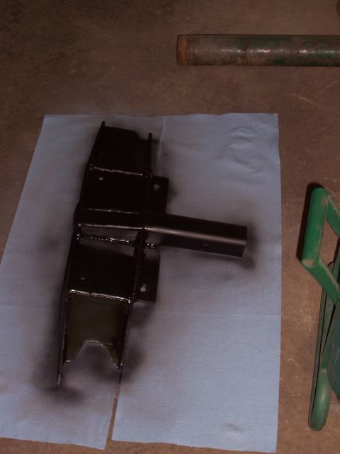 1988 Suzuki Samurai - A black painted metal part rests on blue paper, with a green metal object visible to the right.