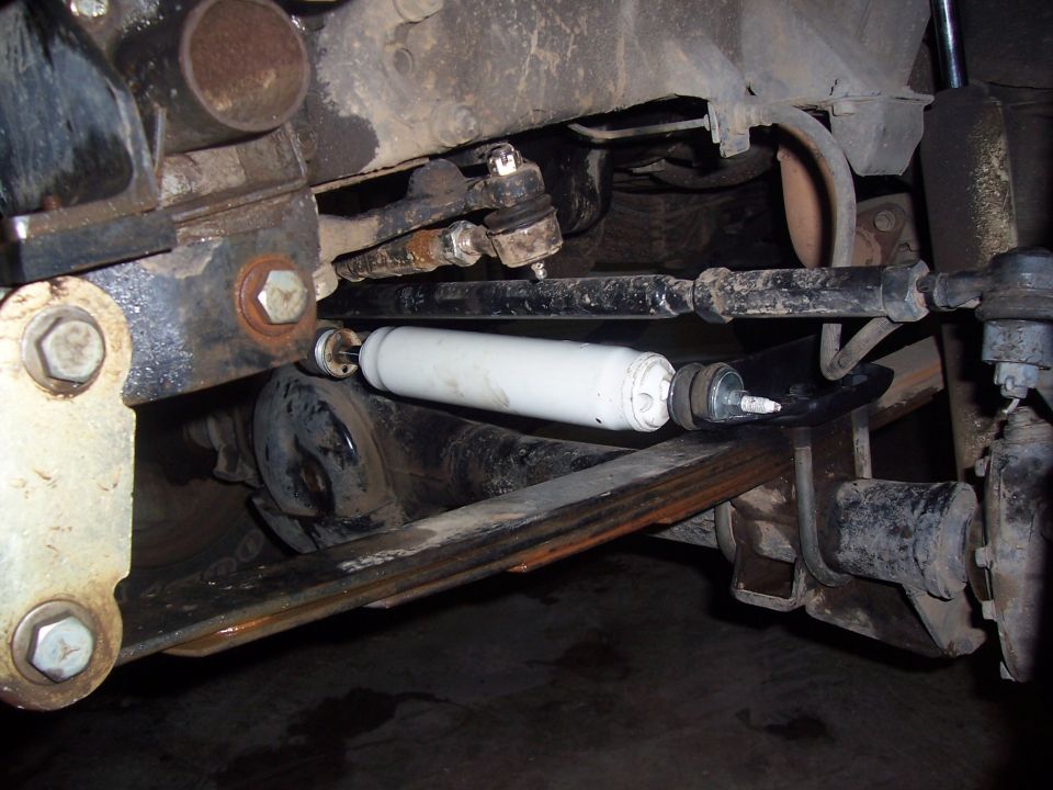 Vehicle front suspension with white shock absorber, tie rods, and leaf spring