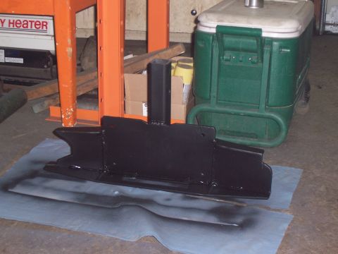 1988 Suzuki Samurai - A black metal part is drying on paper, with a green cooler and orange equipment in the background.