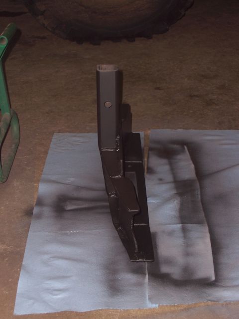 1988 Suzuki Samurai - A dark metal part is shown on a blue paper with overspray from spray paint.