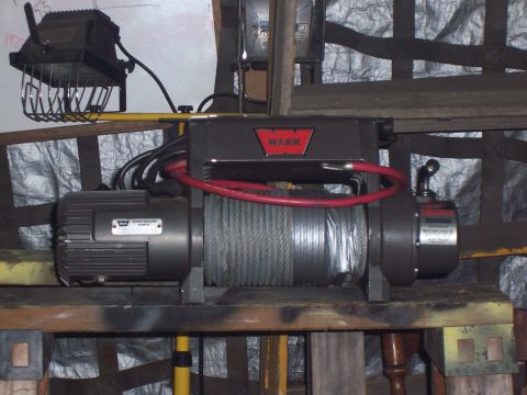 1988 Suzuki Samurai - Warn XD9000i winch assembly with attached motor and wiring, mounted on a wooden platform.