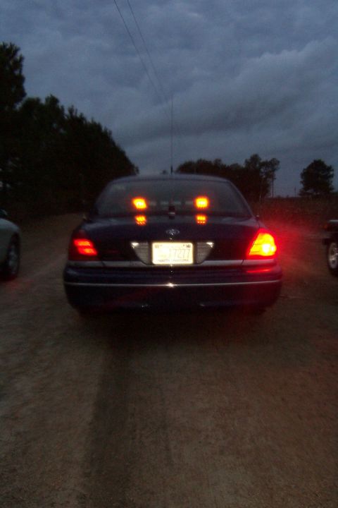 1998 Ford Crown Victoria - Rear view of a dark blue 1998 Ford Crown Victoria with its brake lights on, seen at dusk.