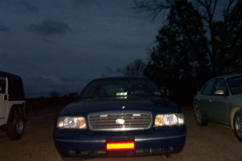 1998 Ford Crown Victoria - 1998 Ford Crown Victoria parked outdoors at dusk with other vehicles nearby.