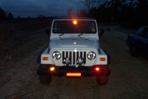 2006 Jeep Wrangler - White 2006 Jeep Wrangler parked outdoors at dusk with hazard lights illuminated.