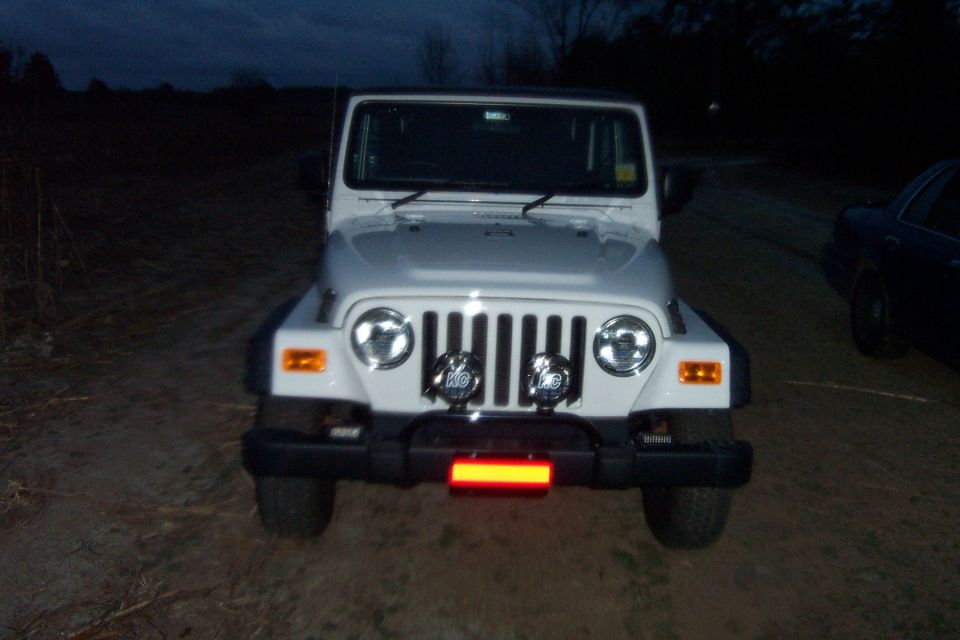 Front view of a white 2006 Jeep Wrangler with aftermarket lights