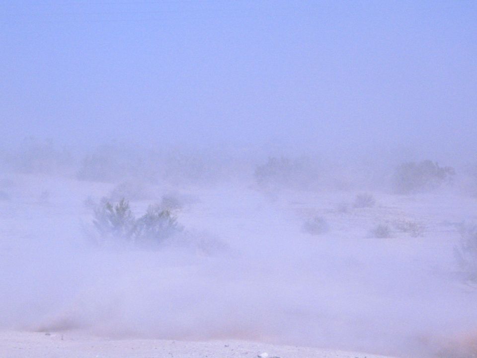 Hazy desert landscape with dust and low brush