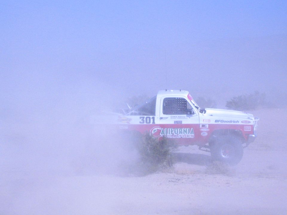 Race truck number 301 spraying sand in the desert