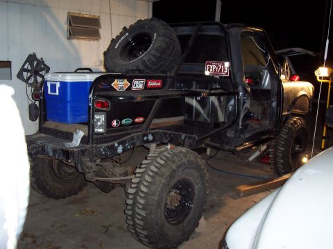 1981 Ford F-150 - This heavily modified truck is parked indoors with a cooler and spare tire mounted on the rear.