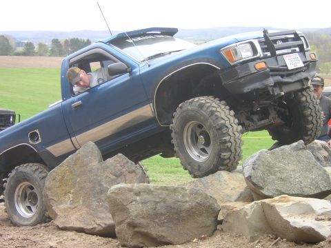 1977 Ford F-150 - This Toyota pickup truck is shown off-roading over a rocky obstacle course.