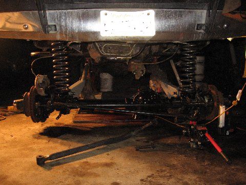1988 Ford Bronco - The vehicle's undercarriage is visible, with suspension parts and springs prominently displayed.