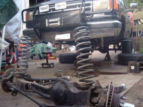 1988 Ford Bronco - Black Ford Bronco front axle and suspension removed, lifted on jack stands for modification.
