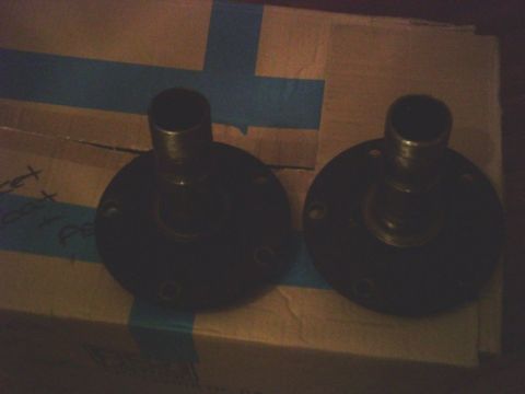 1986 Ford Bronco - Two wheel hubs are shown on a cardboard box with blue tape.