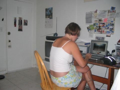 1991 Ford Bronco - A woman sits at a desk using a laptop computer in a room decorated with a calendar and various photos pinned to the wall.