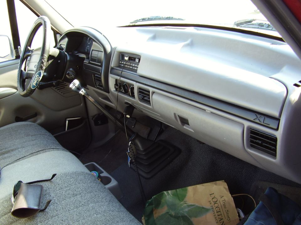 Ford pickup interior with gray dash, XL badge, manual shifter and bench seat