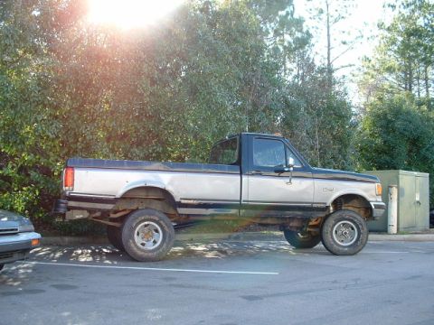 1987 Ford F-150 - This two-tone pickup truck appears to be a 1987 Ford F-150, based on its body style.