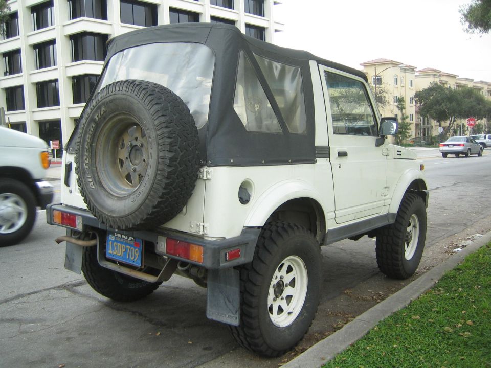 White 1987 Suzuki Samurai convertible SUV, rear view with spare tire