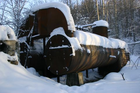 2003 Jeep TJ - An old, snow-covered industrial boiler sits abandoned in a wooded area during winter.