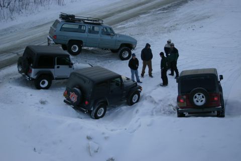 2003 Jeep TJ - Multiple vehicles, including Jeeps and an SUV, are gathered in a snowy landscape with several people present.