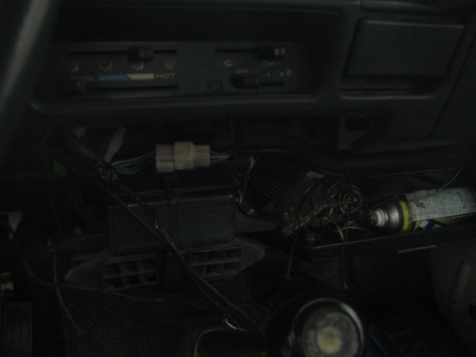 close-up of messy wiring and controls inside a vehicle dashboard
