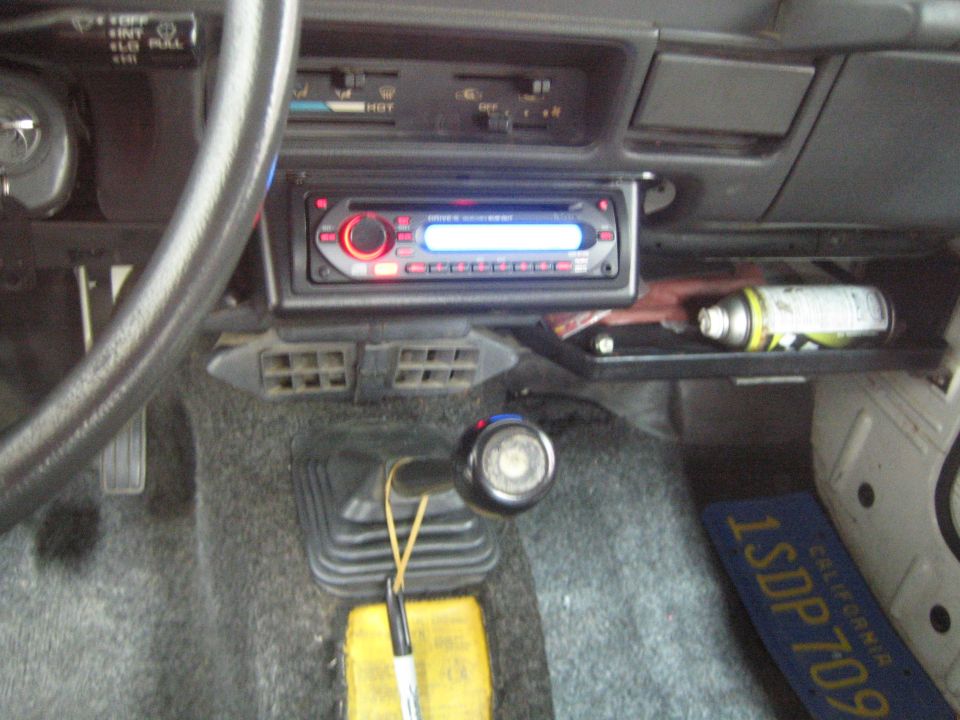Interior view of a vehicle's dashboard with aftermarket stereo and gear shifter