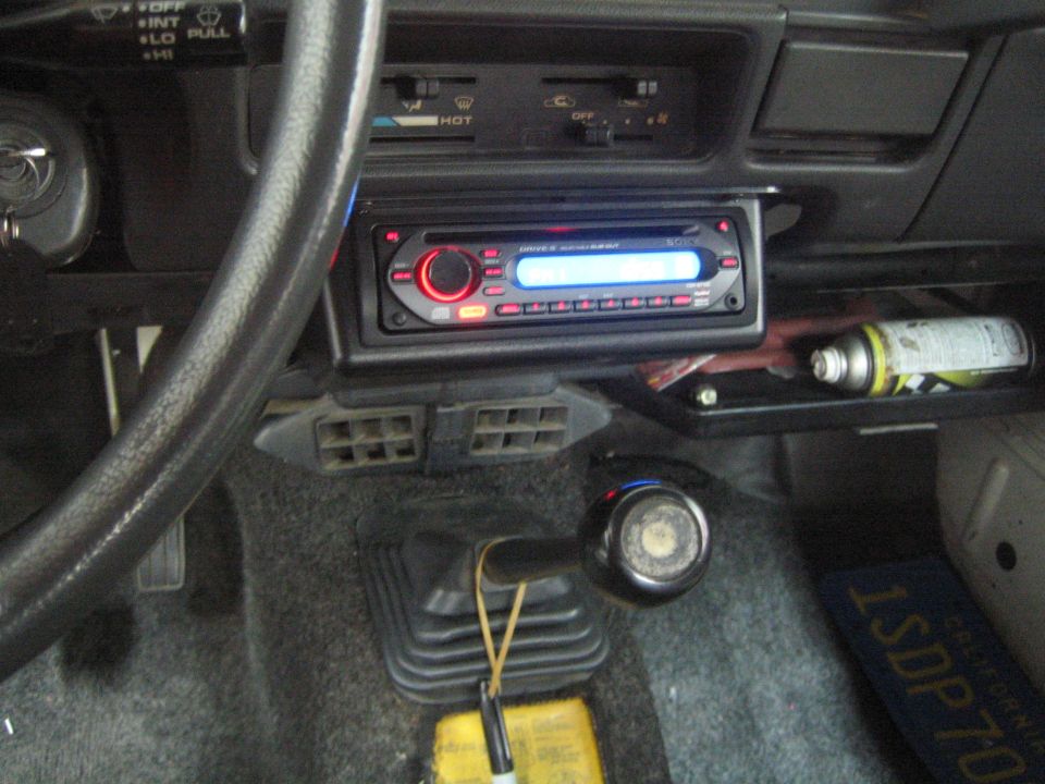 1987 Suzuki Samurai interior showing dashboard, steering wheel, shifter, and aftermarket stereo