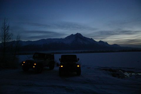 2003 Jeep TJ - Two Jeep Wranglers sit in a snowy field as the sun sets behind a mountain range.