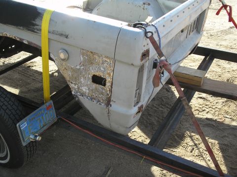 1966 Ford Bronco - Vehicle body panel being transported on a trailer, showing signs of wear and repair.