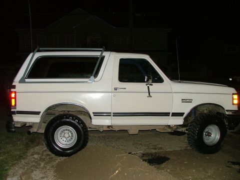 1988 Ford Bronco - This white Ford Bronco appears to be from the late 1980s, with a side profile showing its distinctive body style.